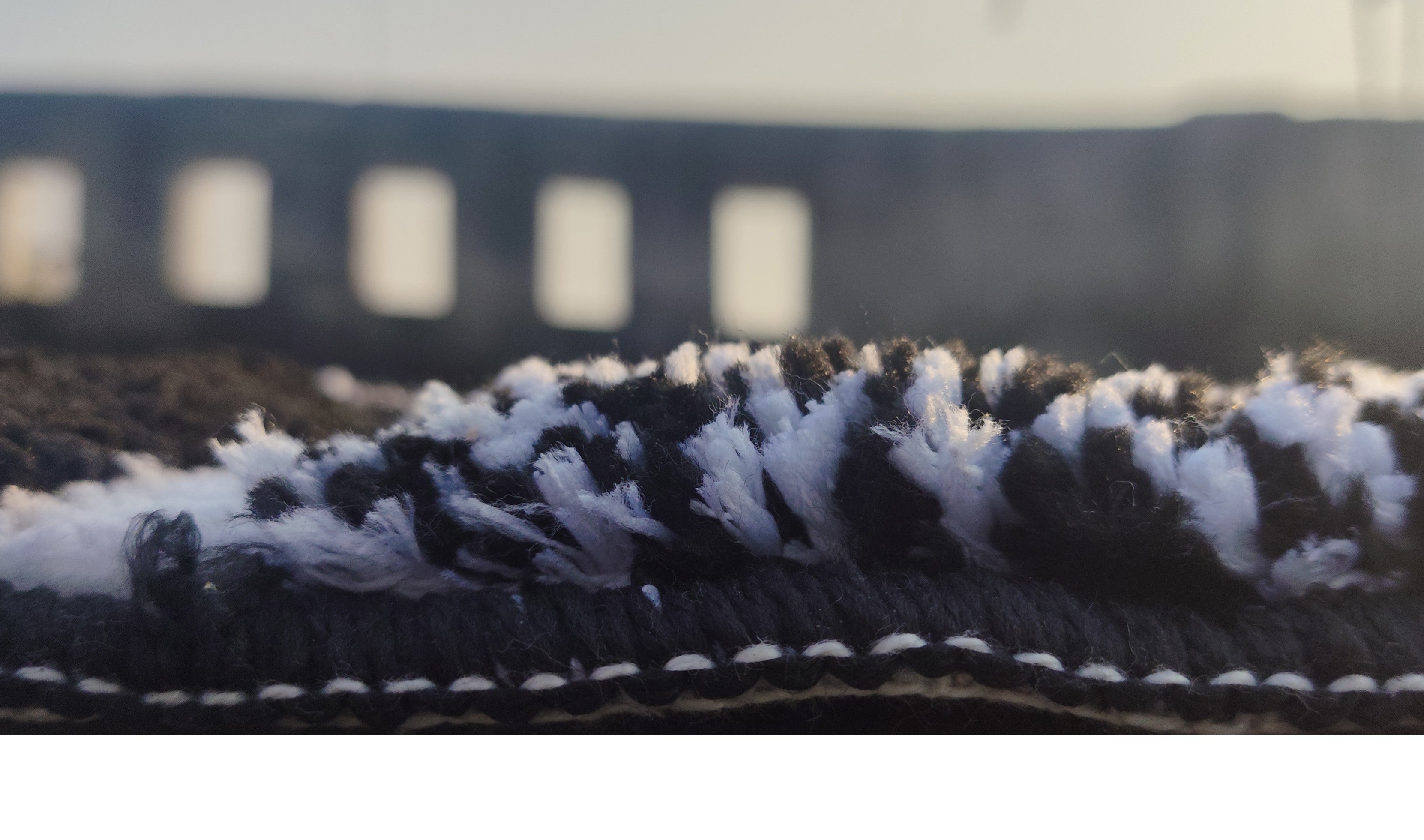 Close-up of microfiber tufted bath mat showcasing black and white design, emphasizing texture and style.
